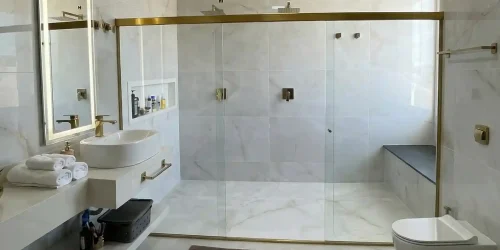 Instalação em vidro temperado para banheiros espaçosos, proporcionando proteção, sofisticação e integração visual com o revestimento do ambiente.